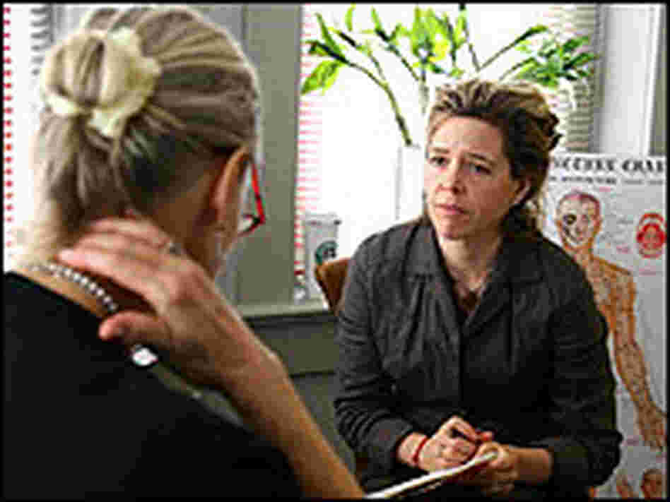 Acupuncturist Kate Yonkers consults with a patient who is having trouble with shoulder pain.