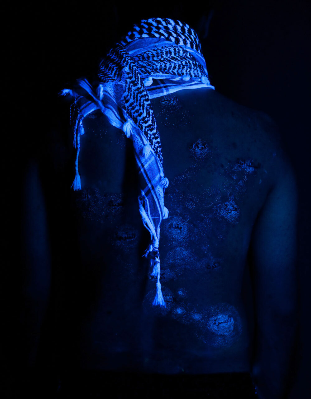 Wafaa Bilal's back as seen under a black light