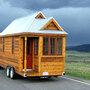 The 130-square-foot "Fencl" tiny house being pulled by a small truck. The 130-square-foot "Fencl" tiny house being pulled by a small truck.