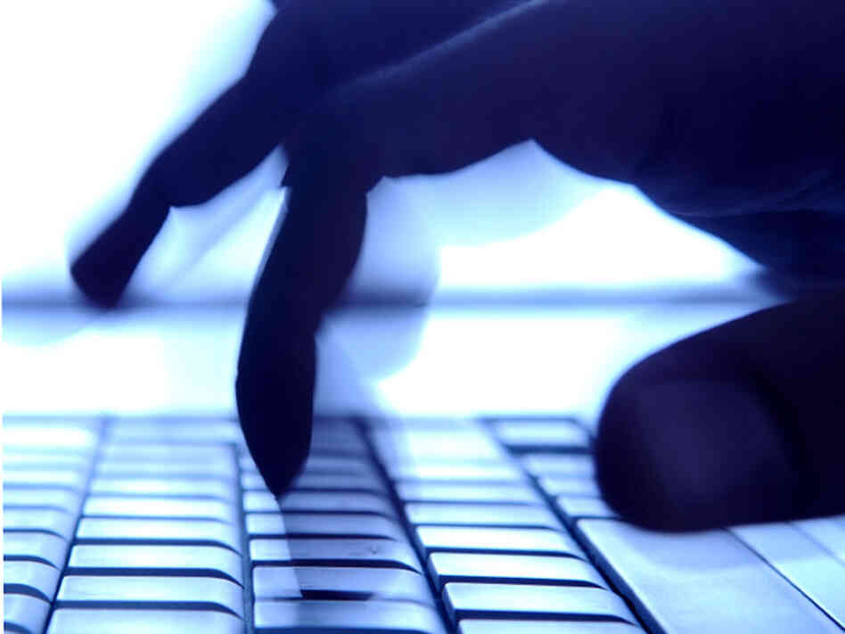 Shadowy fingers typing on keyboard