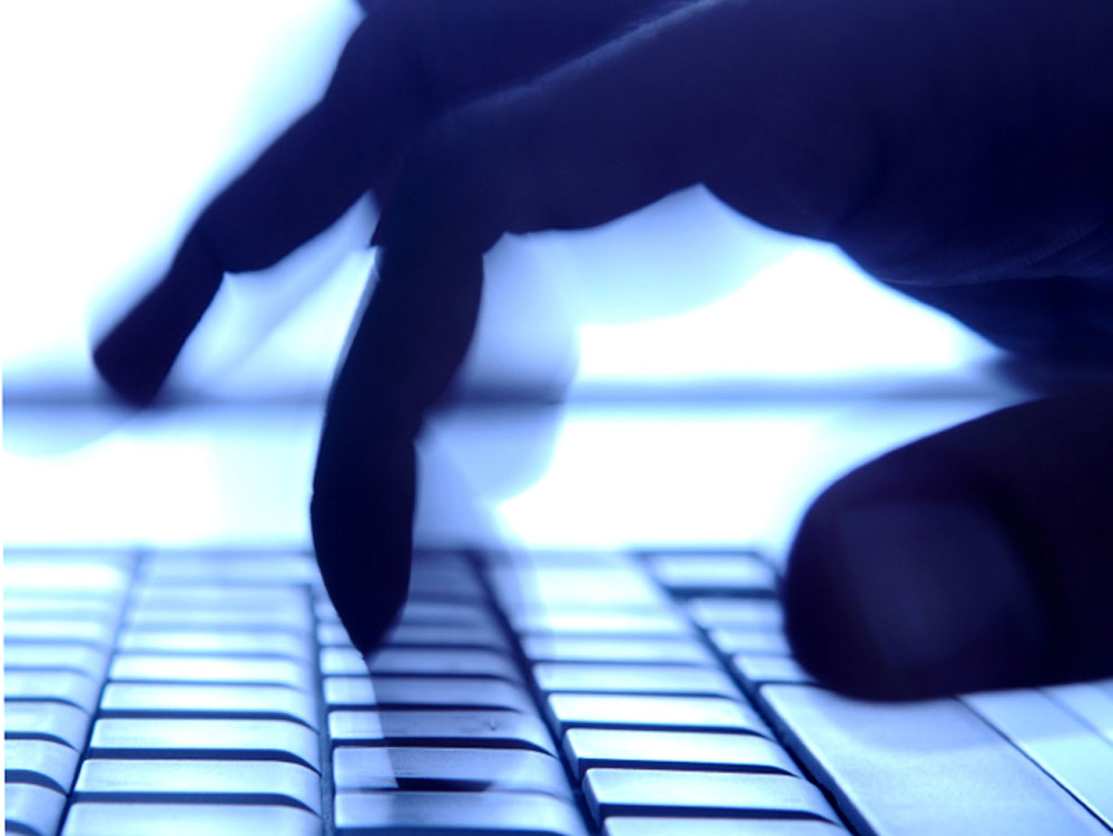 Shadowy fingers typing on keyboard