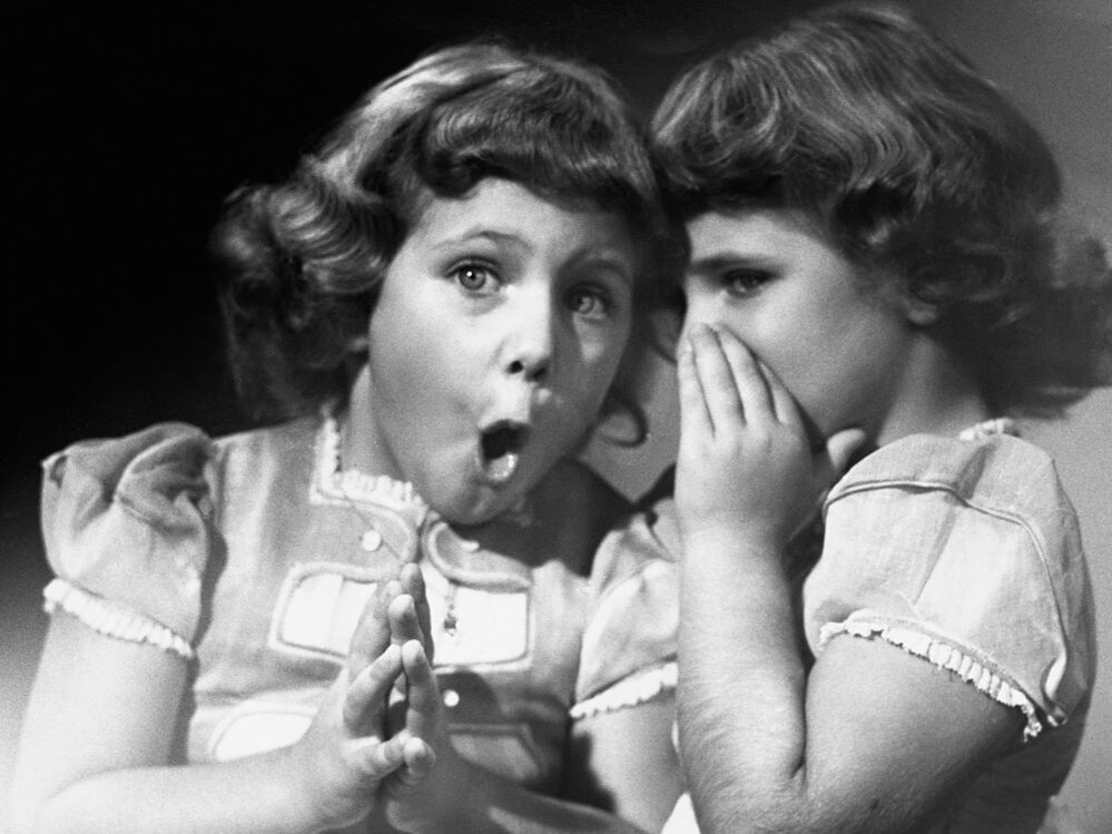 Sisters share a secret, circa 1950.