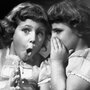 Sisters share a secret, circa 1950. Sisters share a secret, circa 1950.