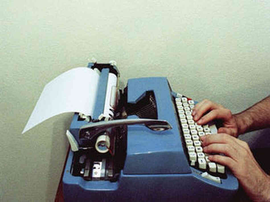 Man types on a typewriter Man types on a typewriter