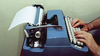 Man types on a typewriter