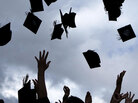 Graduates throw their caps into the air Graduates throw their caps into the air