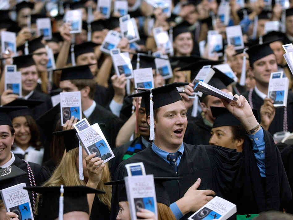 Notre Dame students hold up copies of 'To Kill A Mockingbird' during commencement ceremonies.