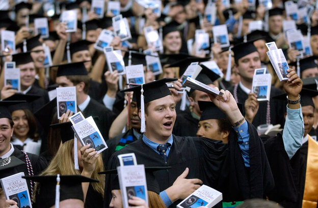 Notre Dame students hold up copies of 'To Kill A Mockingbird' during commencement ceremonies.