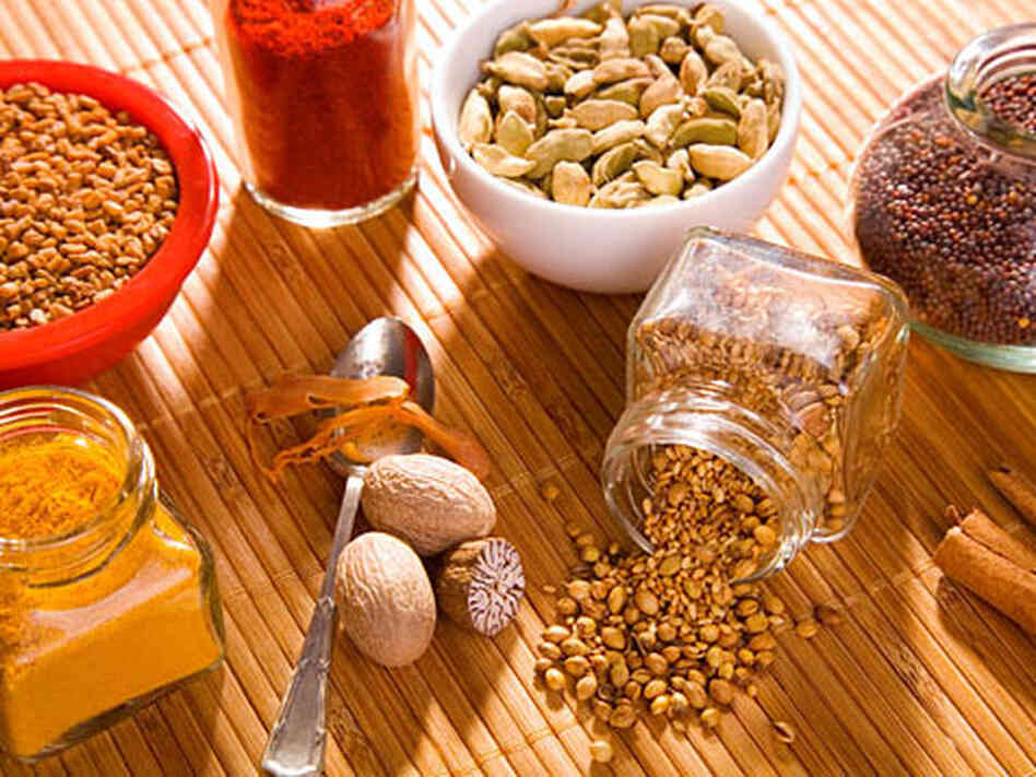 Indian spices in jars and bottles on a bamboo mat