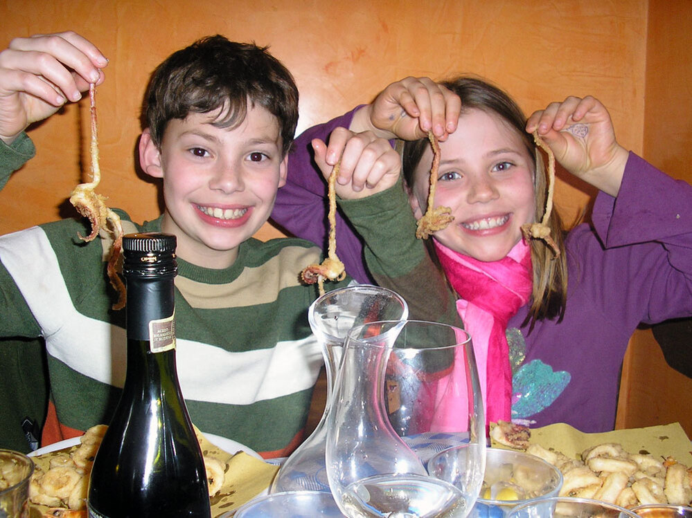 Nick and Adriana Marchetti enjoy fried calamari at a restaurant in Italy