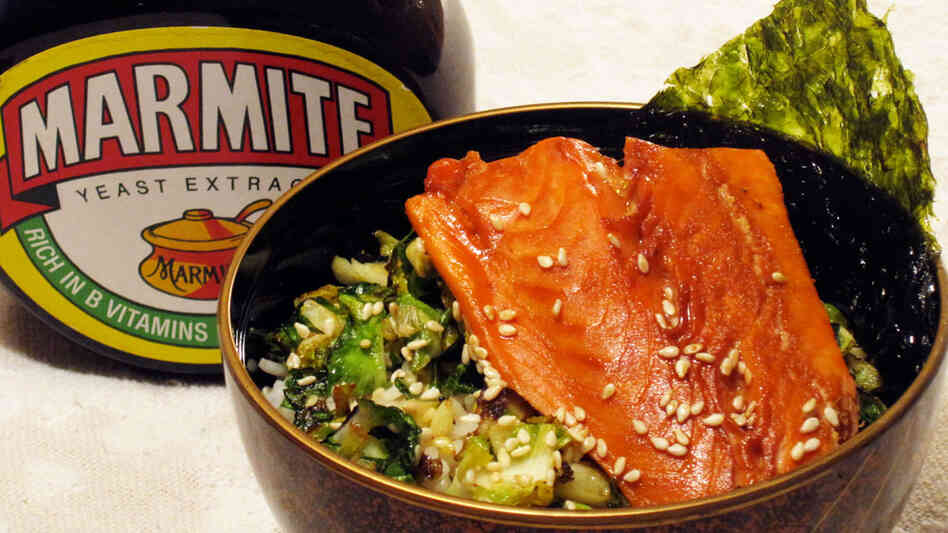 A jar of Marmite next to a bowl of rice topped with glazed salmon