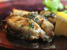 Rockfish roe sauteed with herb butter, on a plate with a lemon wedge and parsley Rockfish roe sauteed with herb butter, on a plate with a lemon wedge and parsley