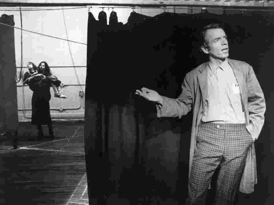 Spalding Gray by a stage curtain