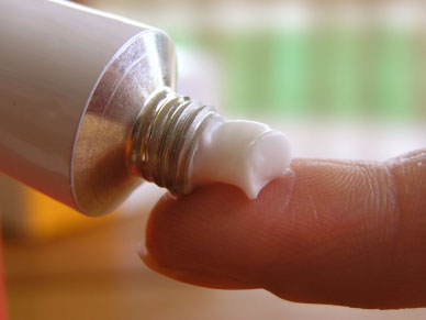 cream squeezed from tube onto a woman's finger