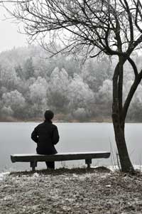 depressed girl looks out at frozen lake