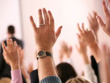 hand raised in town hall crowd