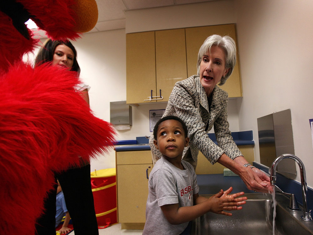 Elmo watches HHS Secretary Sebelius and a friend wash their hands.