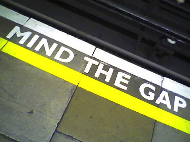 subway platform sign warns: mind the gap