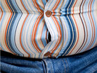 Man's waist bulges in a tight shirt. Man's waist bulges in a tight shirt.