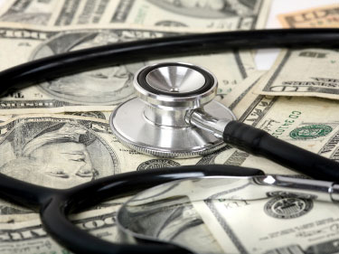 A stethoscope takes the pulse of a pile of money.