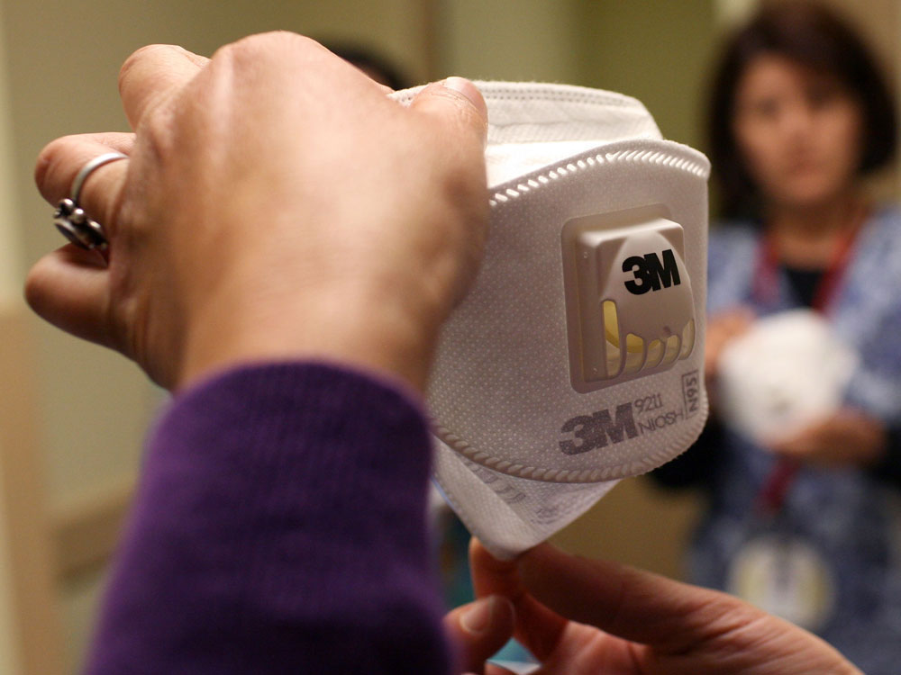 Health worker holds an N-95 mask.