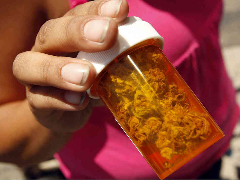 A customer shows medical marijuana she received free at the Roscoe Compassionate Collective in Canog