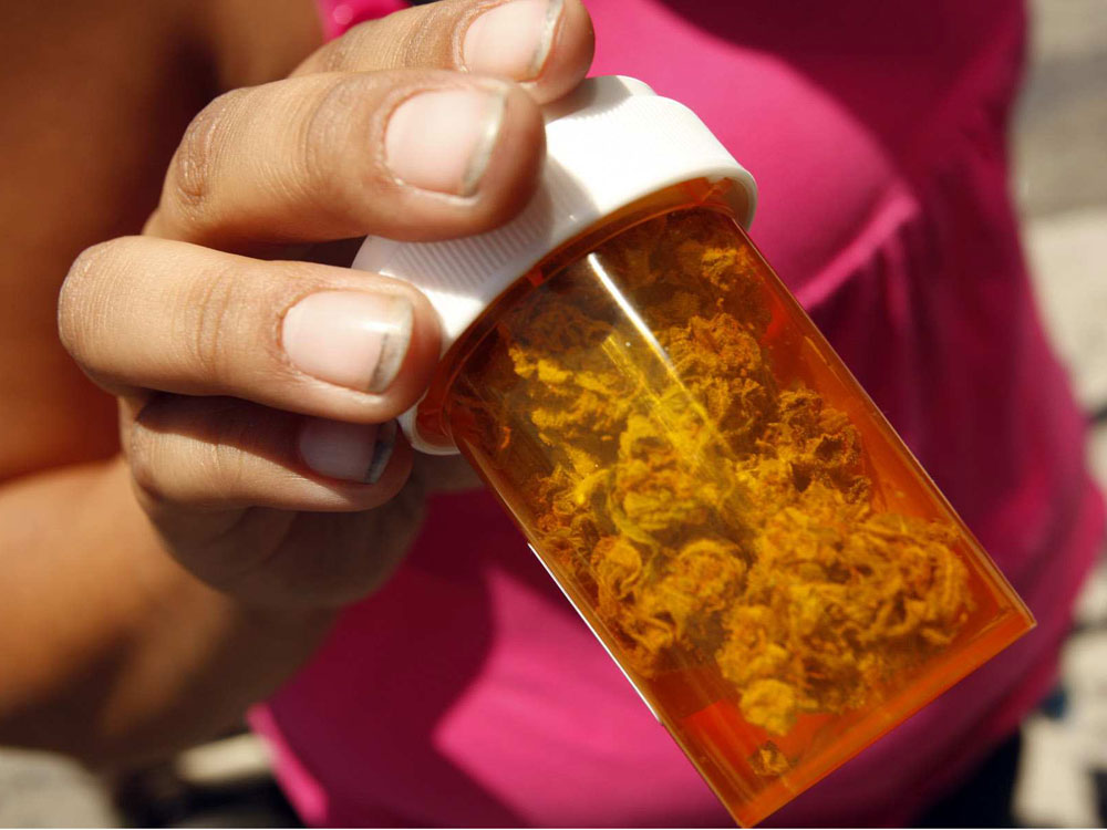  A customer shows medical marijuana she received free at the Roscoe Compassionate Collective in Canoga Park, Calif.
