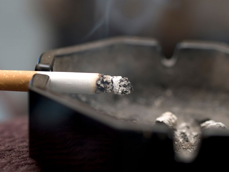Cigarette burns in an ashtray.
