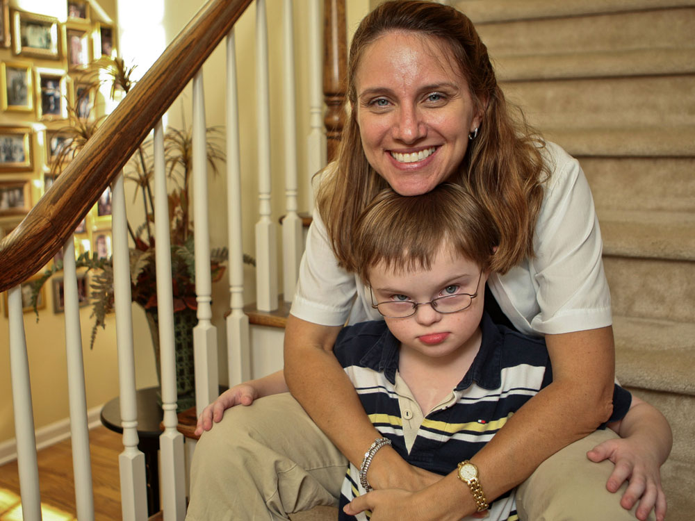 A mother holds her son who has Down Syndrome.