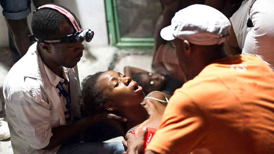 A woman faints in the arms of a medic in an emergency clinic in Petionville on January 12, 2010 in P A woman faints in the arms of a medic in an emergency clinic in Petionville on January 12, 2010 in P