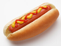 A hot dog in a bun, with mustard.