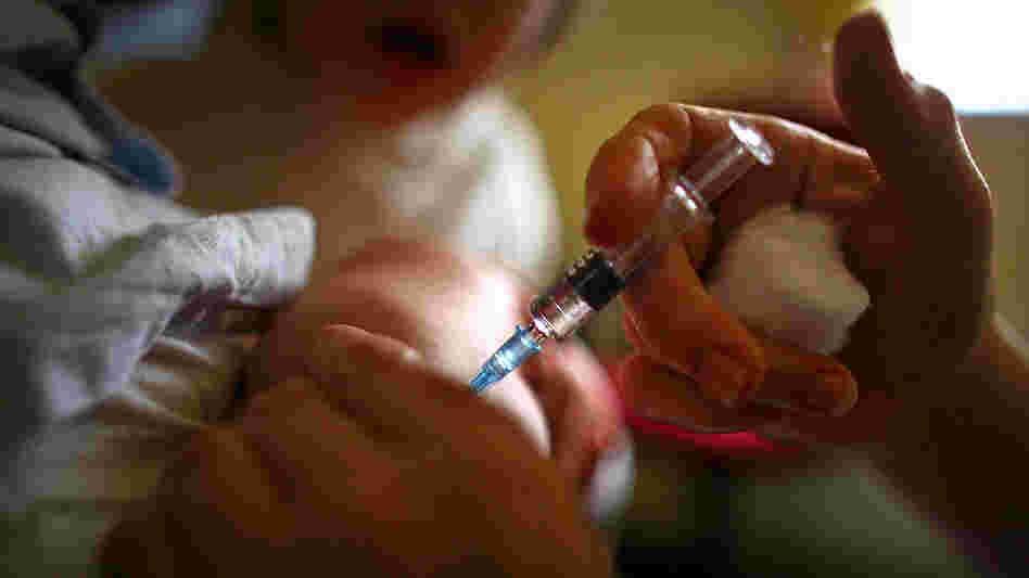 Child gets a vaccination in the arm.