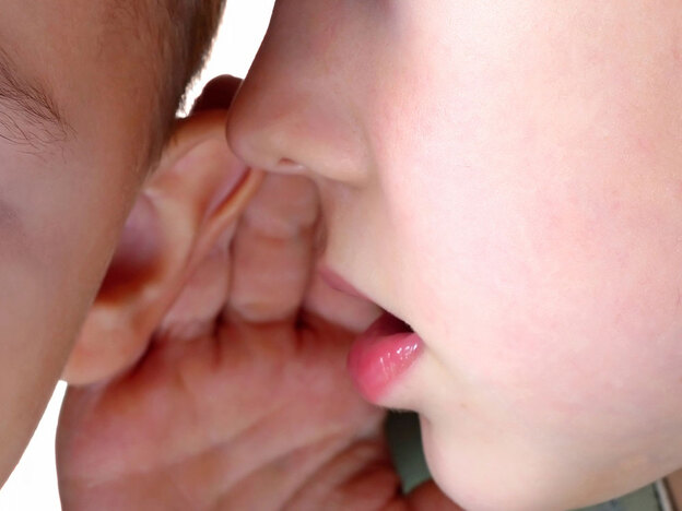One kid whispers to another.