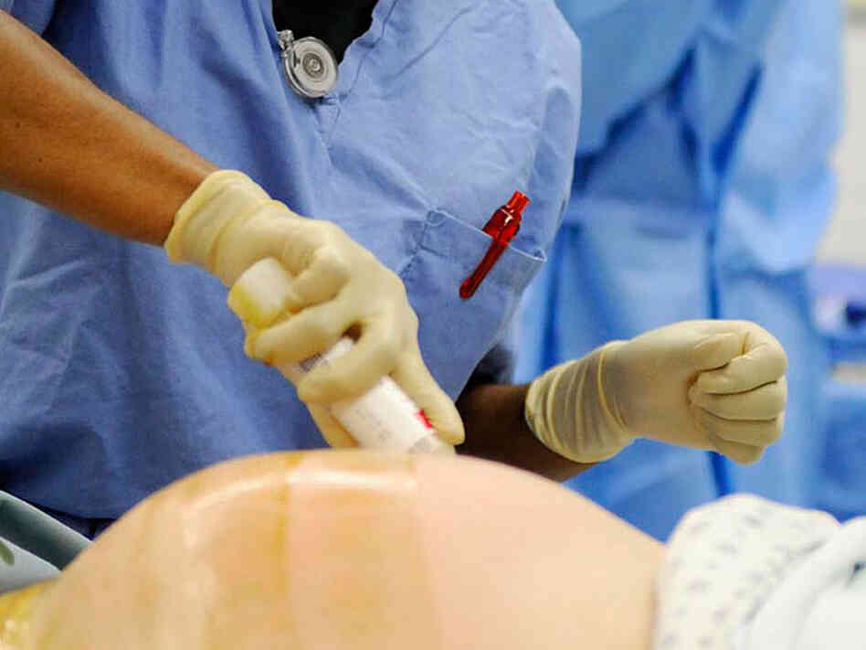 Nurse prepare woman's abdomen for C-section Nurse prepare woman's abdomen for C-section