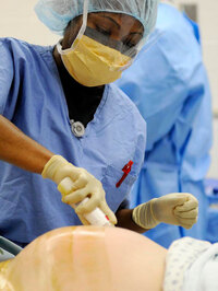 A nurse prepares the abdomen of a woman before a C-section at Malcolm Grow Medical Center near Washington.