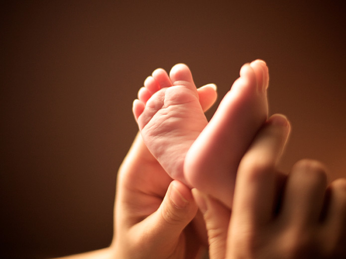 Baby's feet and mother's hands.