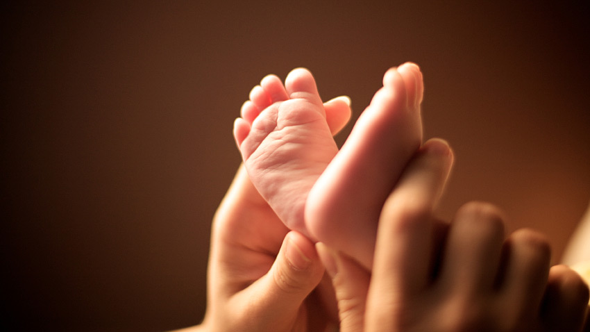 Baby's feet and mother's hands.