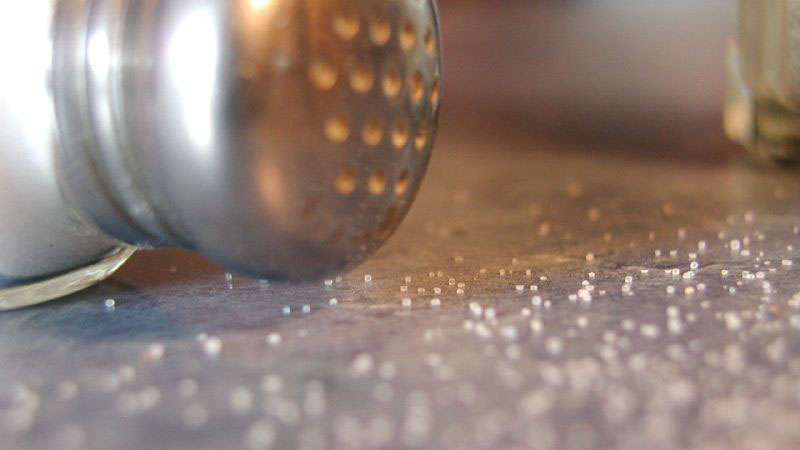 Salt shaker dumped on table.