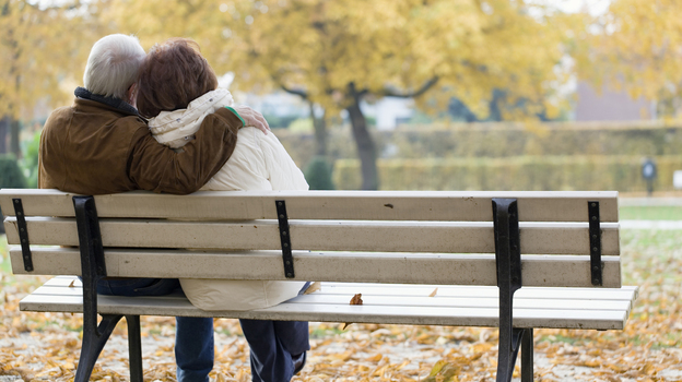 Older couple sitting on park bench.