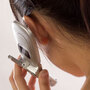 Woman holds cellphone close to her ear.