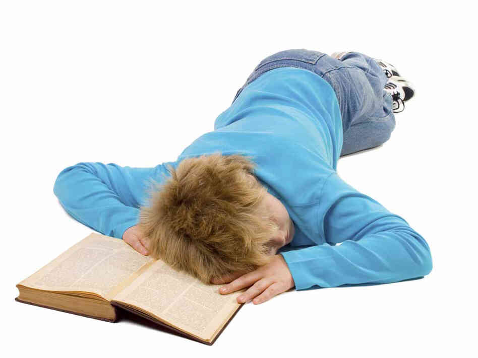 Teen boy sleeping on a book.