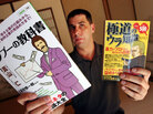 Jake Adelstein holds up manga magazines based on the yakuza Jake Adelstein holds up manga magazines based on the yakuza