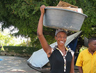 A woman carries a large bucket of goods on her head in Haiti. A woman carries a large bucket of goods on her head in Haiti.