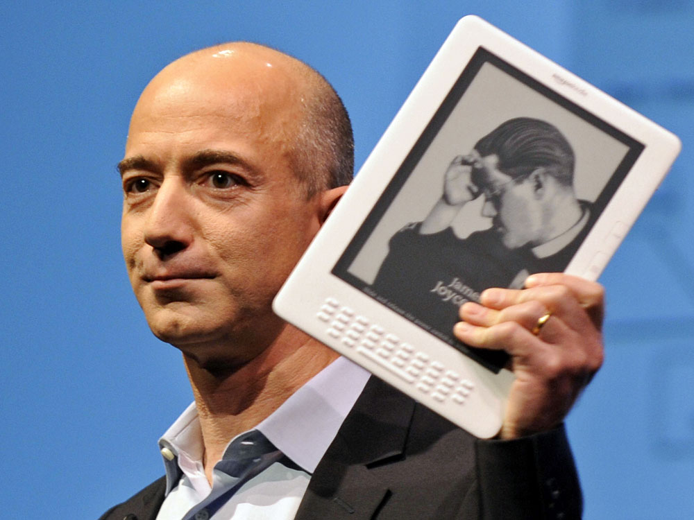 Amazon CEO Jeff Bezos and a Kindle. Emmanuel Dunand/AFP/Getty Images
