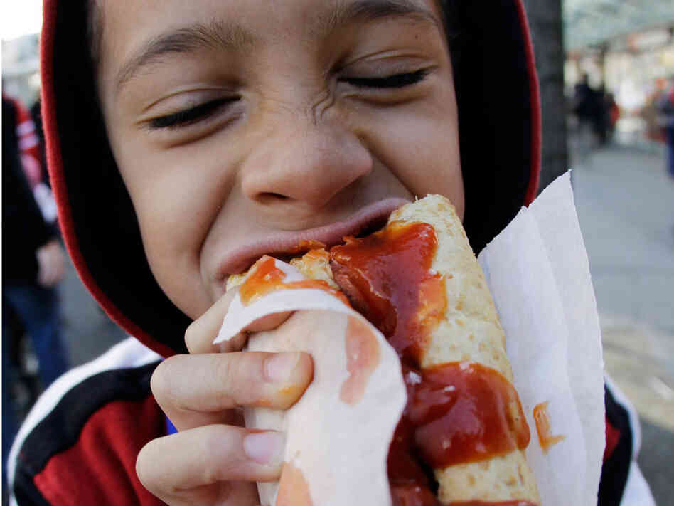 Keegan Hasan eats a hotdog. Keegan Hasan eats a hotdog.