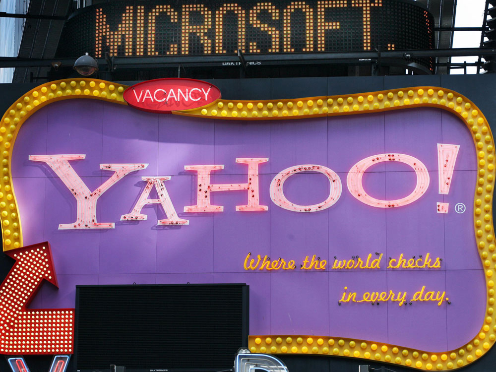 May 4, 2007 file photo of Times Square news ticker flashes a headline about Microsoft above a billboard for Yahoo in New York. (AP Photo/Mark Lennihan, File)
 