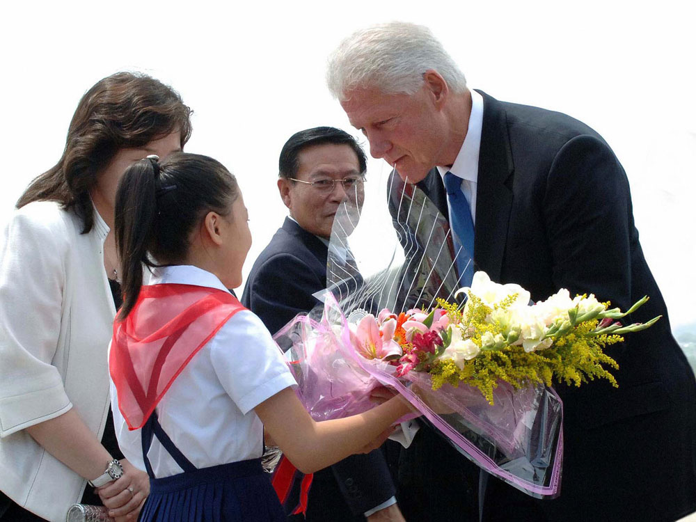 This photo taken on August 4, 2009 and released by North Korea's official Korean Central News Agency shows former US president Bill Clinton (R) receiving a bouquet of flowers from North Korean girl upon his arrival at Pyongyang airport. KNS/AFP/Getty Images.