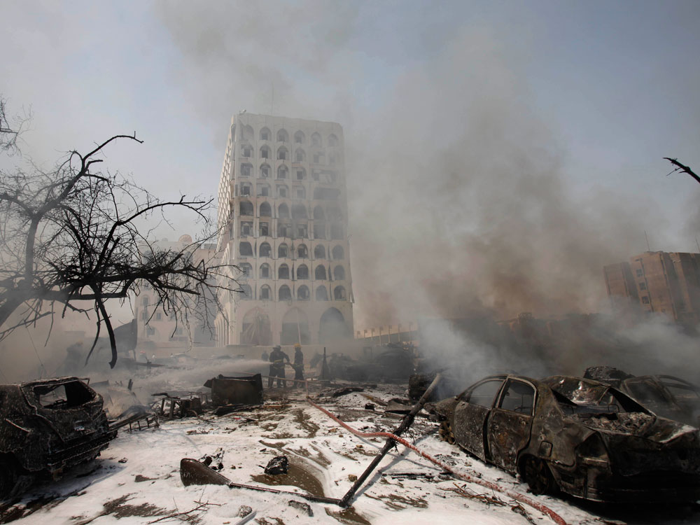 The Iraqi Foreign Ministry is seen through a haze of smoke after a massive bomb attack in Baghdad, Iraq, Wednesday, Aug. 19, 2009. A series of deadly explosions targeting government and commercial buildings struck Baghdad Wednesday, killing scores and wounding more than 300, Iraqi police and medical officials said. (AP Photo/Khalid Mohammed)