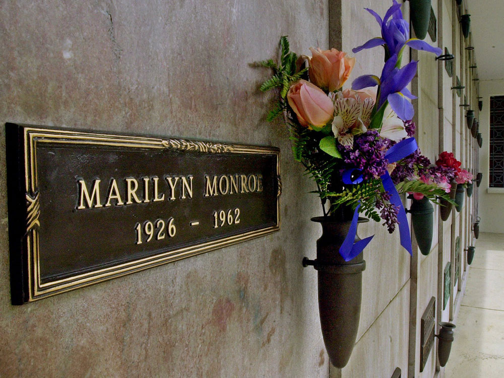 A bouquet of fresh flowers adorns the crypt of movie star Marilyn Monroe, heavily smudged from the hands of thousands of visitors, at Westwood Cemetery in Los Angeles' Westwood District, April 20, 2001. (AP Photo/Reed Saxon)