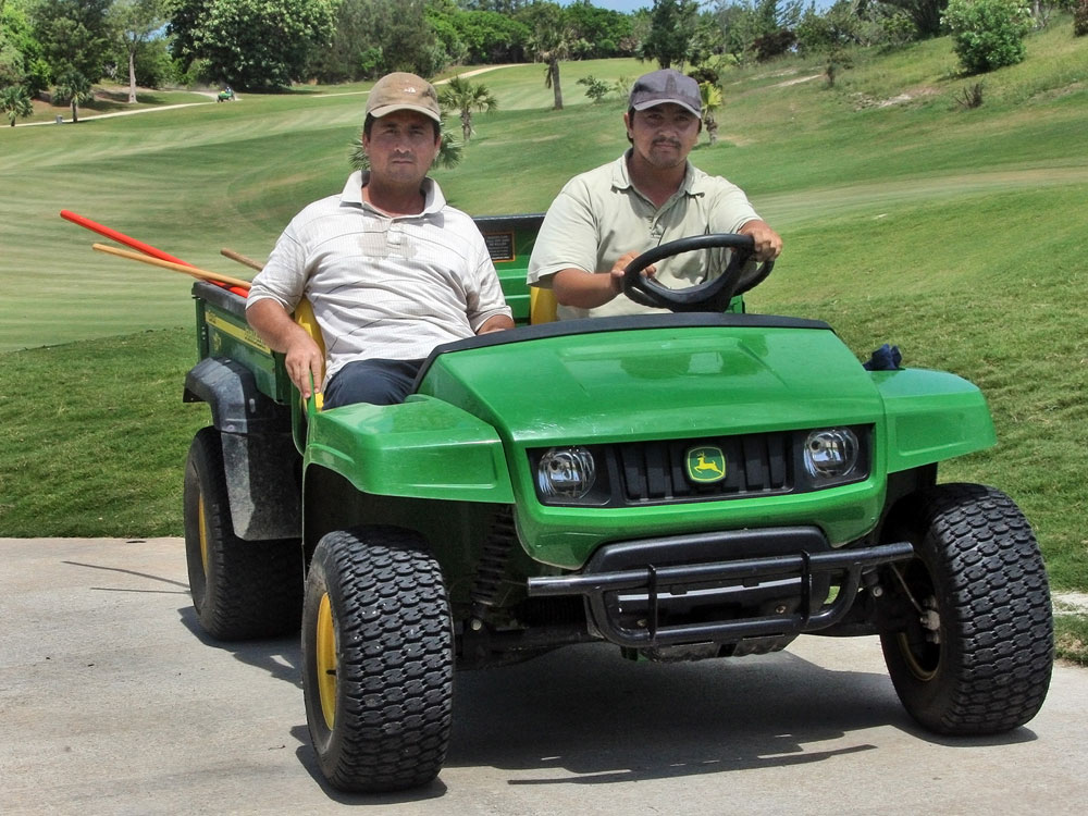 Former Guantanamo detainees Ablakim Turahun, left, and Abdulla Abdulqadir pose for a picture at their new jobs as landscapers for the Port Royal Golf Course, in Southampton, Bermuda, Tuesday, Aug. 4, 2009. (AP Photo/Mark Tatem, The Royal Gazette) 
